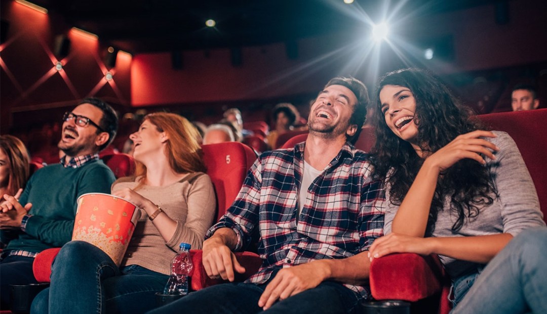Two Couples laughing in a movie theatre