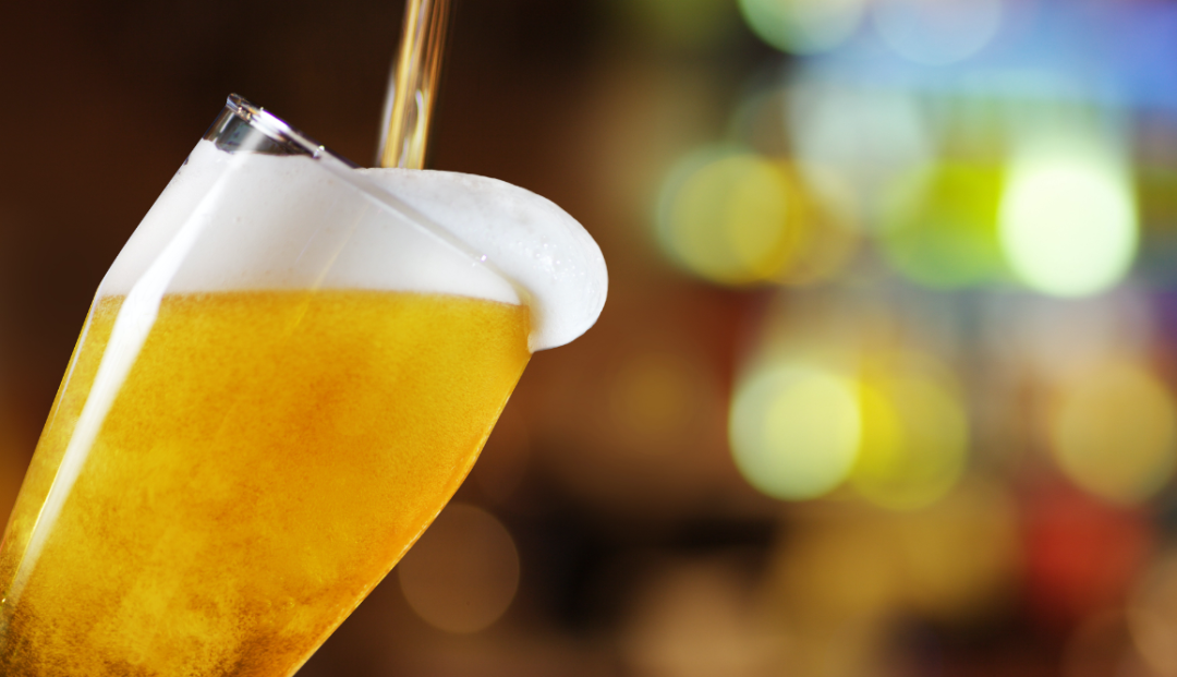 a photo of beer in a glass with foam on top